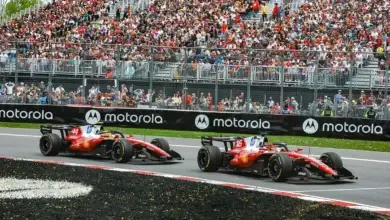 Two Ferrari cars push aggressively through the Circuit Gilles‑Villeneuve during the Canadian Grand Prix, running close together at high speed.