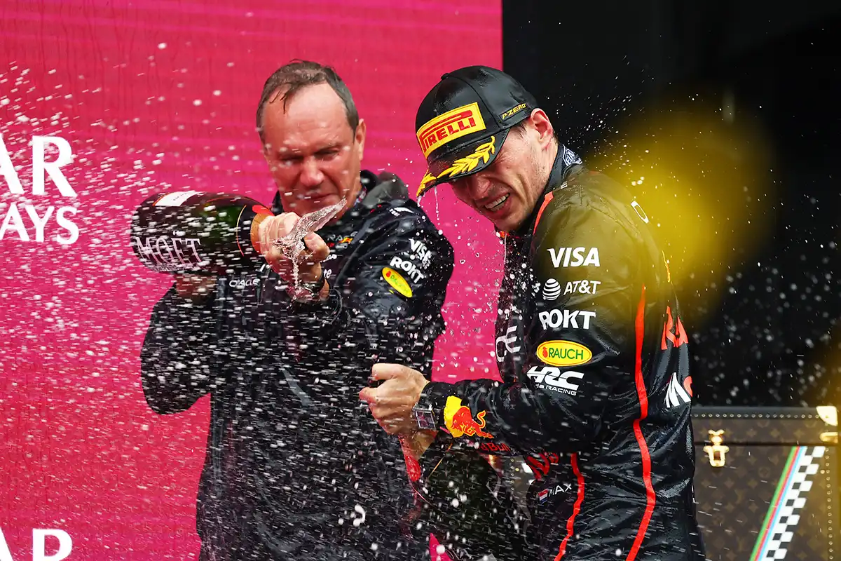 Max Verstappen and Paul Monaghan celebrating with champagne on the podium after winning the Azerbaijan Grand Prix, amid ongoing Red Bull staff‑departure tensions and engineering‑leadership uncertainty.