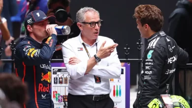Max Verstappen, Stefano Domenicali and George Russell talking in parc ferme after the 2025 Australian Grand Prix, with Domenicali central to ongoing F1 2026 Middle East finale discussions.