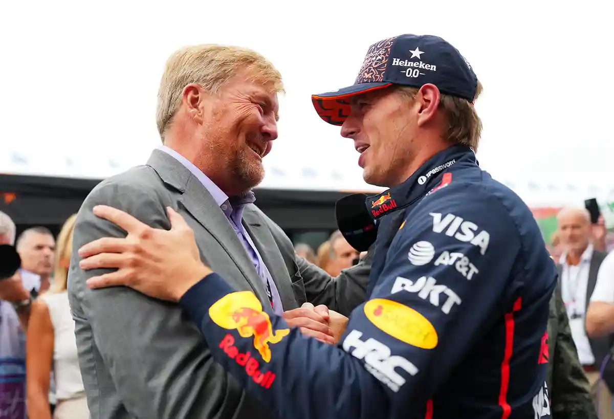 Max Verstappen speaking with King Willem‑Alexander on the grid before the 2025 Dutch Grand Prix at Circuit Zandvoort, photographed by Alex Bierens de Haan for Getty Images, during the build‑up to the Zandvoort F1 final race farewell.