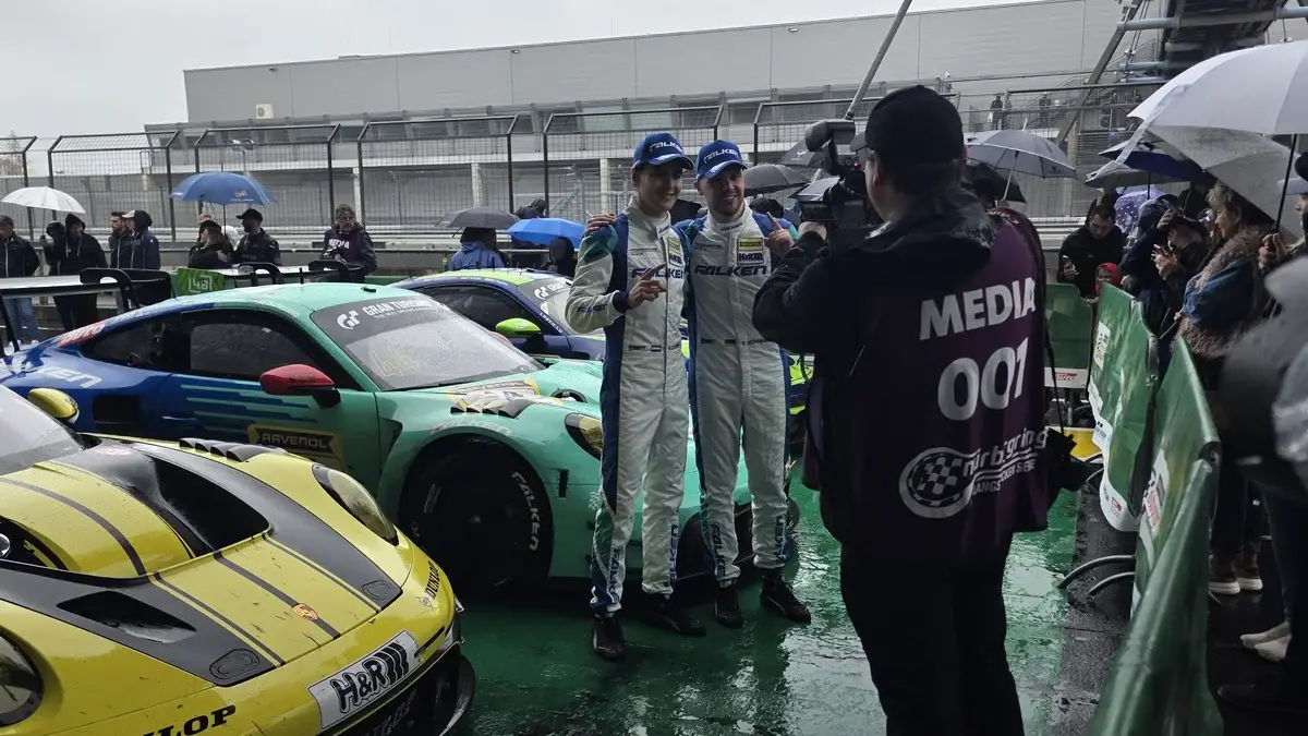 The winning Falken Motorsports drivers in parc ferme beside the number 44 Porsche after NLS9