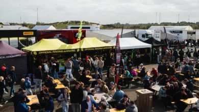 Spectators at tables and merchandise stands in the fan village at Circuit Zandvoort
