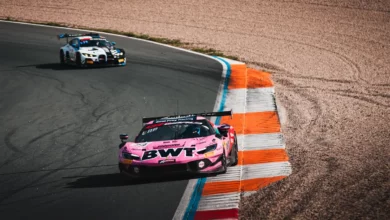 The pink BWT number 14 Emil Frey Racing Ferrari 296 GT3 Evo on the kerbs at Zandvoort