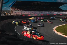 The GT World Challenge field three wide through the banked Hugenholtzbocht on the first lap of Race 2 at Zandvoort