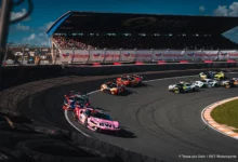 Both Emil Frey Racing Ferraris at the front of the field at the Hugenholtzbocht on the opening lap of Race 2 at Zandvoort