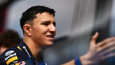 Isack Hadjar talking in the paddock in Red Bull team kit