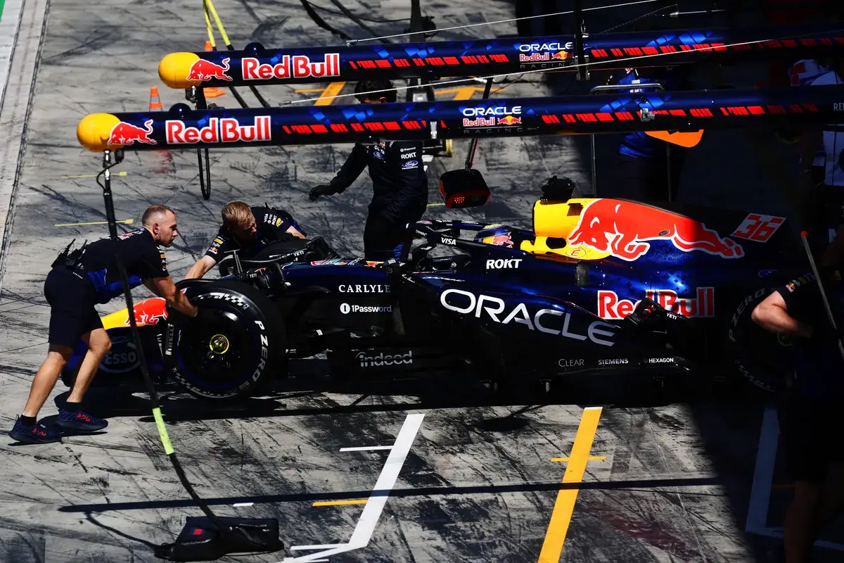 Mechanics push Ayumu Iwasa's Red Bull back into the garage at Monza
