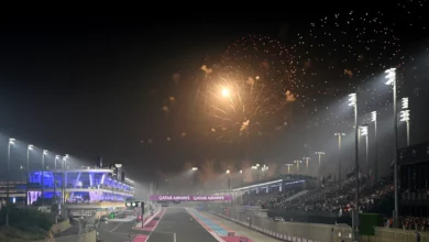 Formula 1 cars on the start-finish straight at the floodlit Lusail International Circuit in Qatar with fireworks overhead