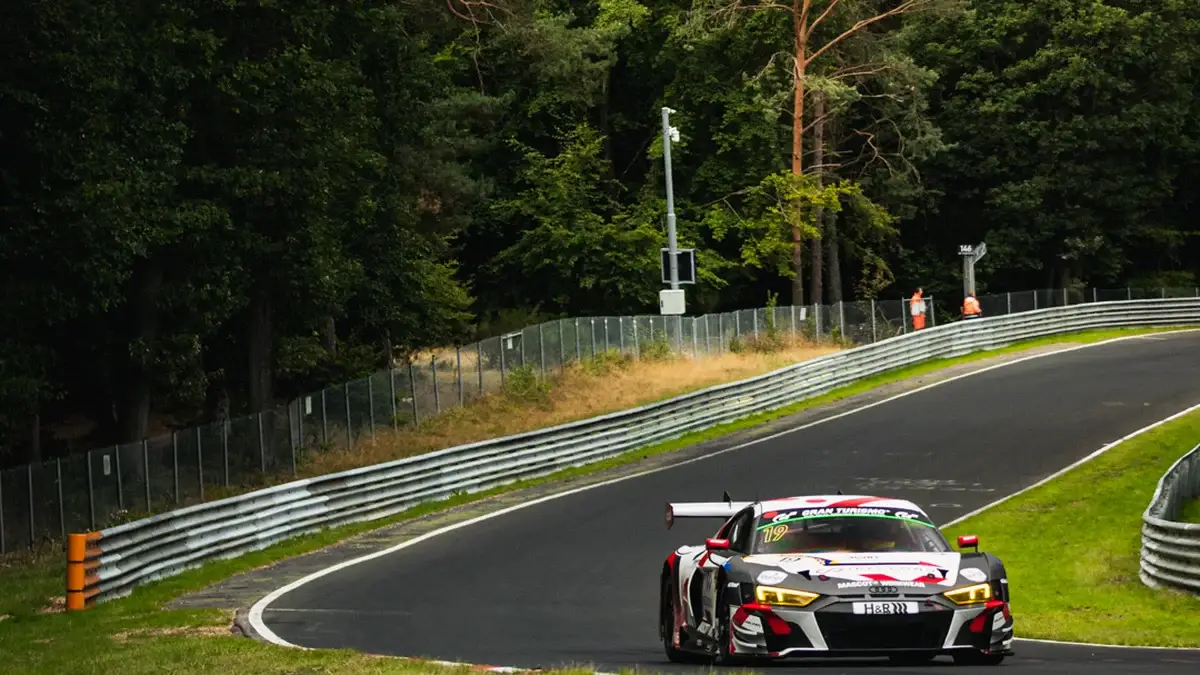The number 19 Max Kruse Racing Audi R8 LMS GT3 on the Nordschleife with the Nurburg castle behind