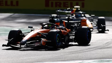 A McLaren leads a Red Bull past the Pirelli boards at Monza