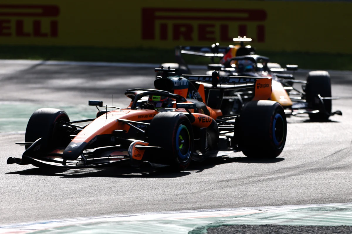 A McLaren leads a Red Bull past the Pirelli boards at Monza