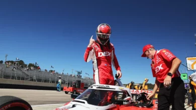 Scott McLaughlin standing beside his car holding up one finger after taking pole