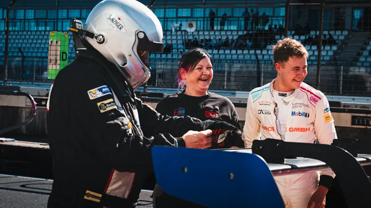A driver in conversation with his crew during Friday practice at the Nurburgring