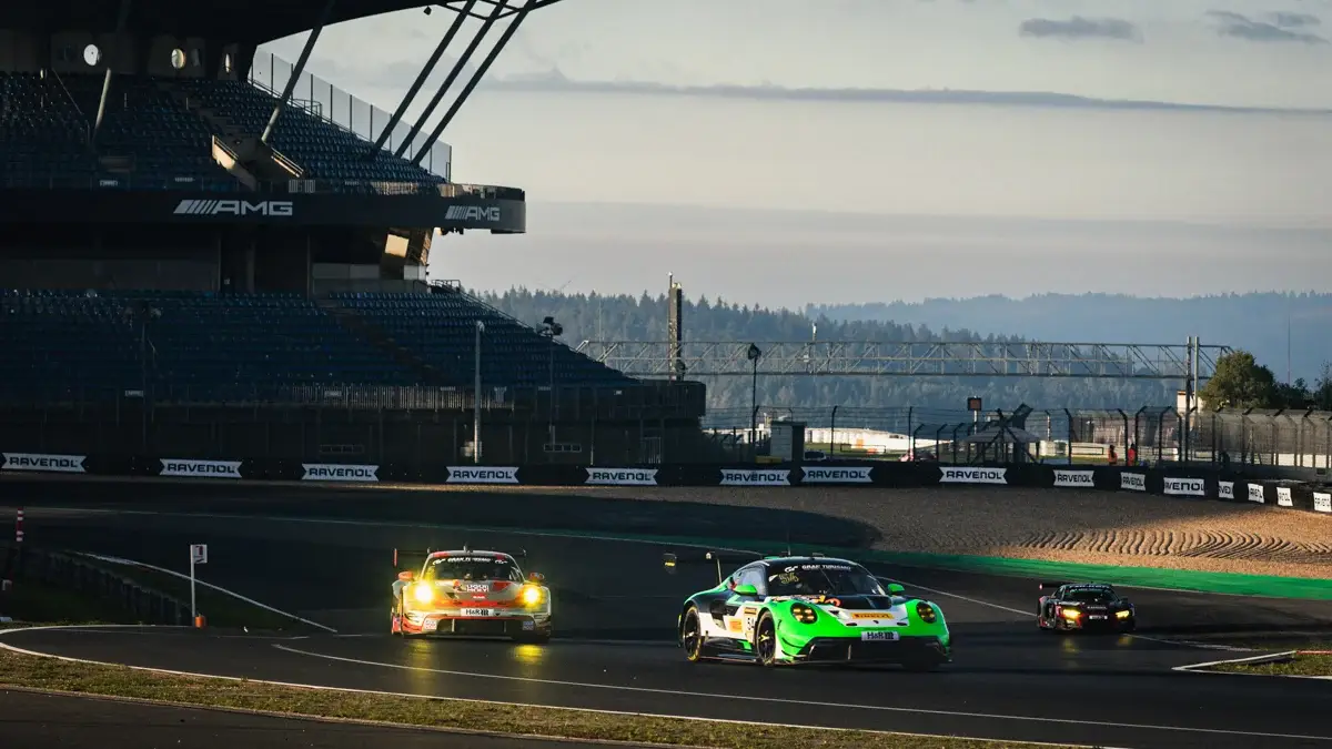 A green Manthey Porsche 911 GT3 R leads an orange Porsche through the Grand Prix circuit at the Nurburgring