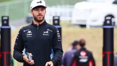 Pierre Gasly in Alpine team kit walking through the paddock