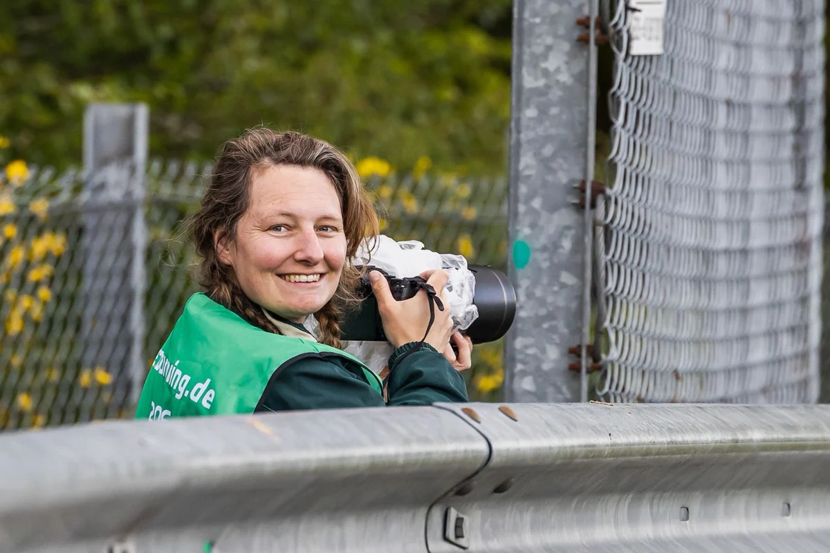 Tessa van Duin photographing a race weekend trackside for RNT-Motorsports, with a telephoto lens and press bib