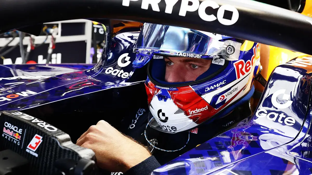 Max Verstappen sits in the cockpit of his Red Bull in the garage at the Madring, helmet on and visor up