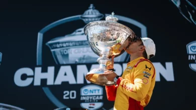Alex Palou kisses the Astor Challenge Cup on the 2026 IndyCar champion's stage