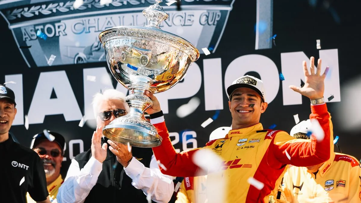 Alex Palou holds up the Astor Challenge Cup in confetti on the IndyCar champion's stage