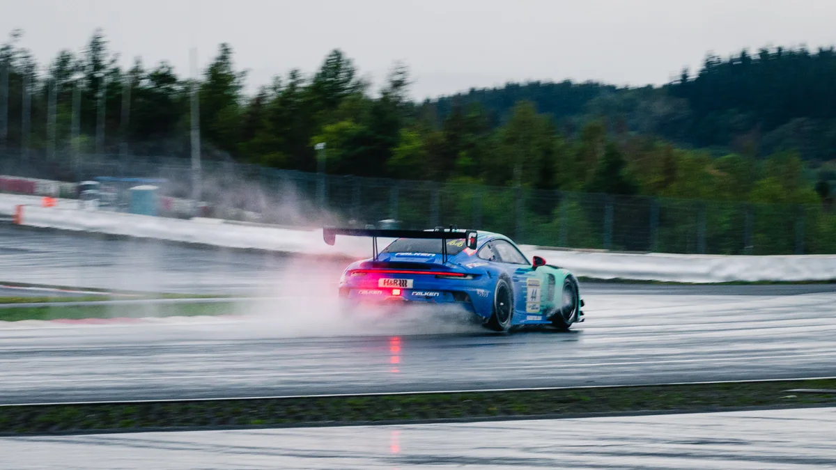 The number 44 Falken Motorsports Porsche 911 GT3 R throwing up spray on a wet track during NLS9