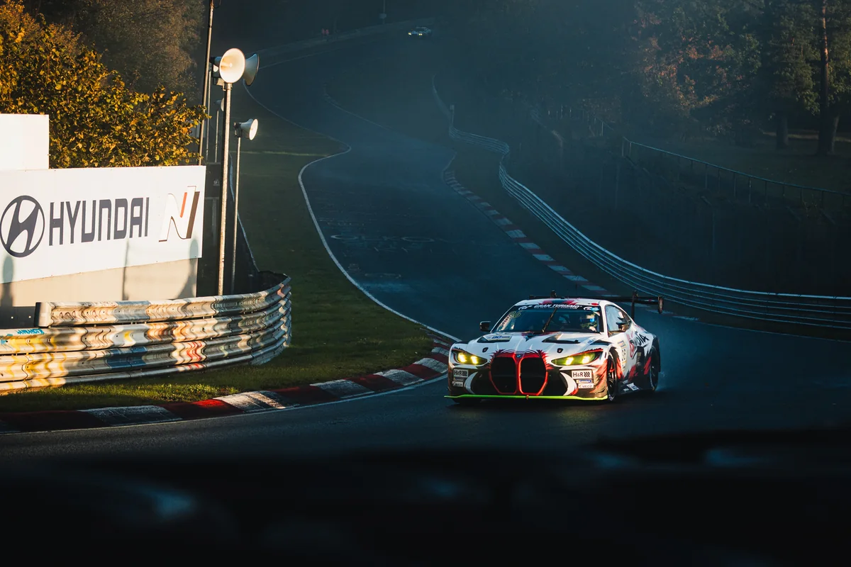 The number 36 Gamota Racing BMW M4 GT3 EVO in low morning sun with mist behind it during NLS10 qualifying at the Nurburgring