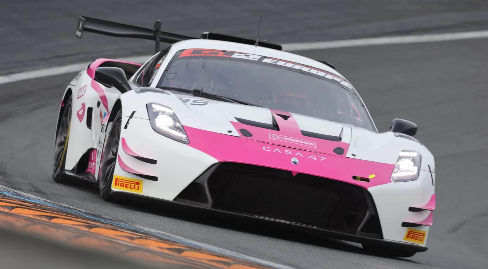 The #85 Iron Dames Maserati MC20 GT2 cornering with its headlights on at Zandvoort in September 2026