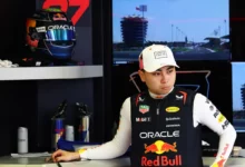 Ayumu Iwasa in Red Bull team kit in the garage, his helmet on the shelf behind him