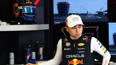 Ayumu Iwasa in Red Bull team kit in the garage, his helmet on the shelf behind him