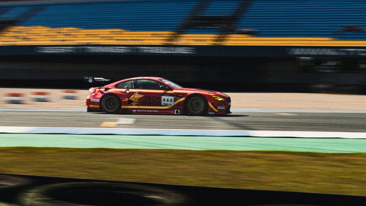 Red BMW M6 GT3 number 111 passing the empty grandstand at TT Circuit Assen