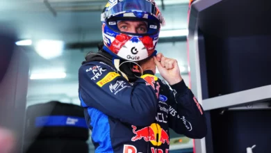 Max Verstappen putting on his helmet in the Red Bull garage before practice at Sepang