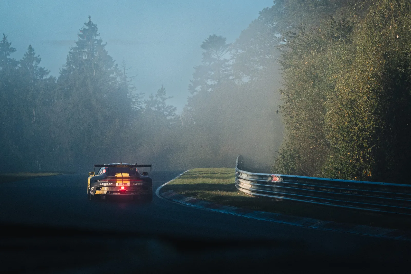 A GT car comes out of the morning fog on the Nordschleife during NLS 10.
