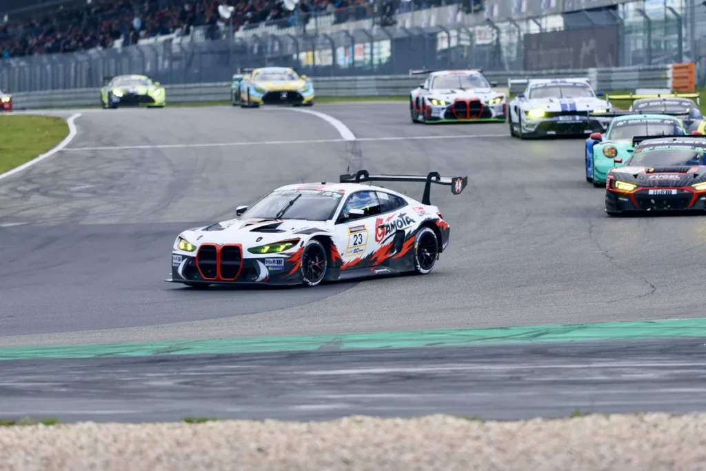 The number 23 Gamota Racing BMW leads the number 75 Audi and the number 44 Falken Porsche on the Nurburgring Grand Prix circuit during NLS10