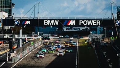 Both Gamota Racing BMW M4 GT3 EVOs lead the field under the BMW M Power bridge at the start of NLS10 at the Nurburgring