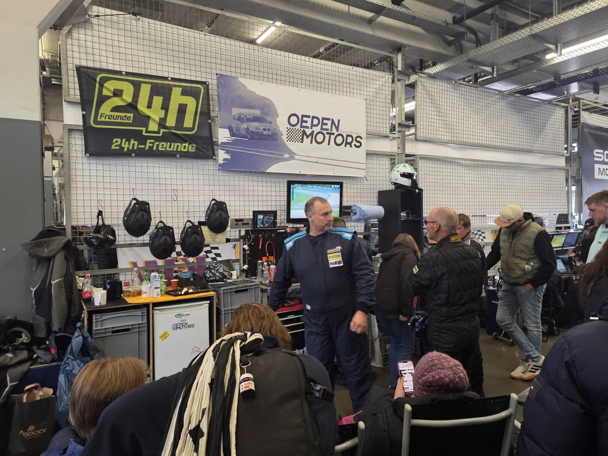 The Oepen Motors garage in the Nurburgring pit building during NLS10, with team members and visitors