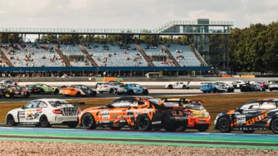 Supercar Challenge field with a white BMW M2 and an orange BMW M4 in front of the grandstand at TT Circuit Assen