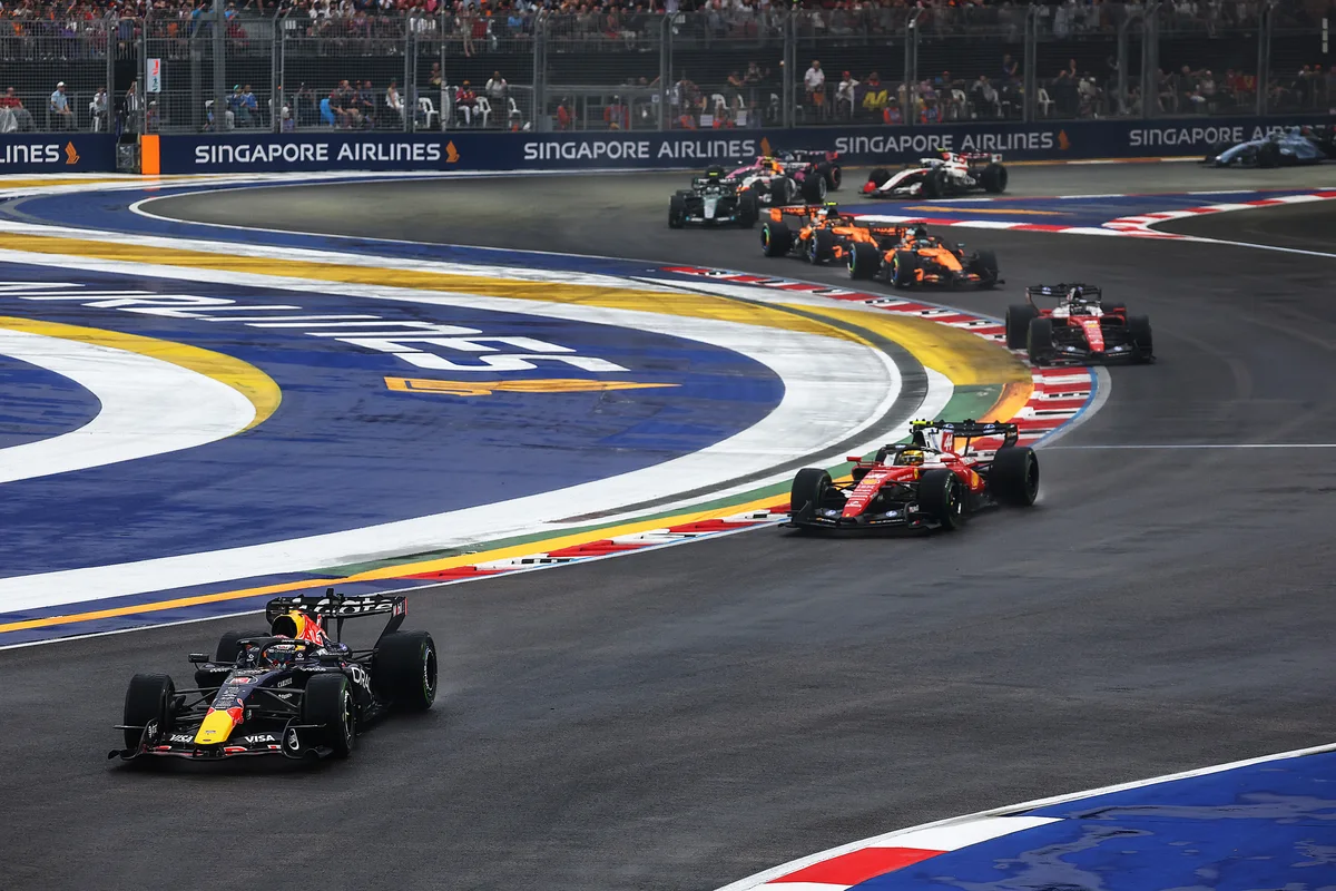 Max Verstappen in the Red Bull leads Lewis Hamilton in the Ferrari at the restart of the Singapore Sprint, with the field behind on a damp track