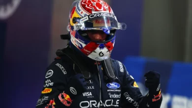 Max Verstappen in his helmet celebrates pole position in parc ferme after qualifying for the 2026 Singapore Grand Prix