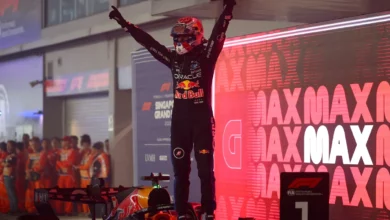 Max Verstappen stands on his Red Bull in parc ferme with arms raised after winning the 2026 Singapore Grand Prix